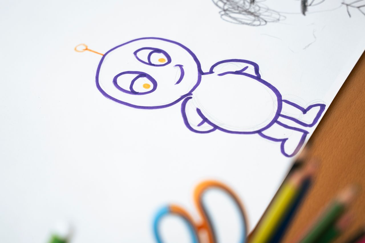 Home Colorful cartoon character sketch on paper with colored pencils on the side.